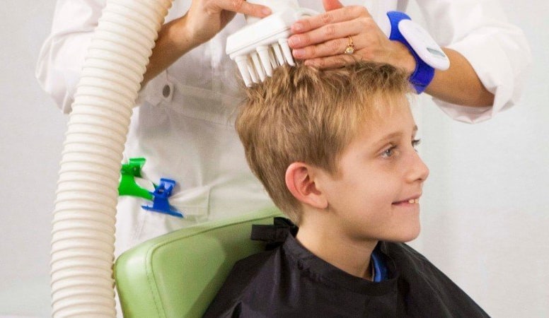 boy getting lice removed using a AirAlle machine from a licensed professional